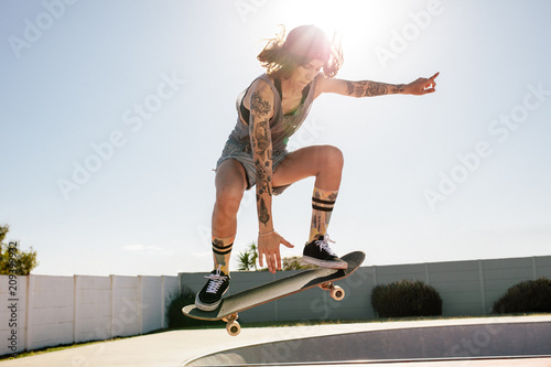 Women skater doing ollie on skateboard photo