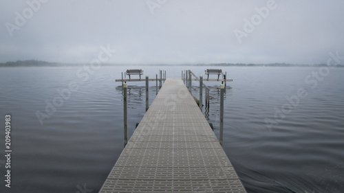 Dock with benches on foggy lake in Bemidji Minnesota