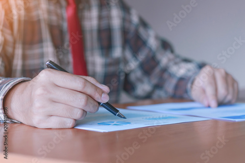 business man or lawyer accountant working using a pen and writing on documents