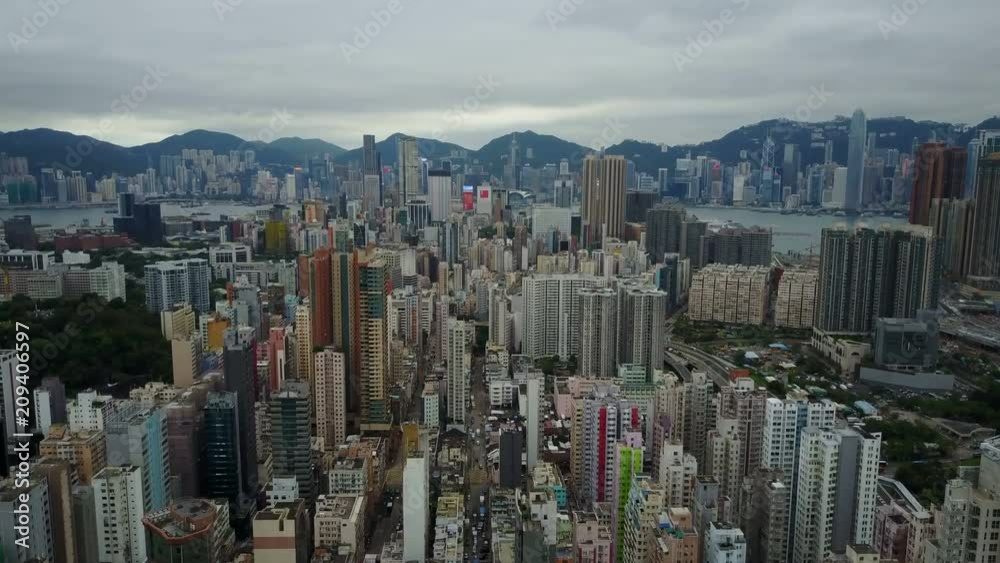 Establishing drone shot flying over tall skyscrapers in Kowloon towards modern Hong Kong skyline Establishing drone shot flying over tall skyscrapers in Kowloon towards modern Hong Kong skyline