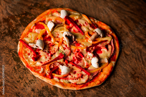 Home Italian pizza on a dark rustic wooden background. Concept pizza with bulgarian pepper and tomatoes with cheese with space for text