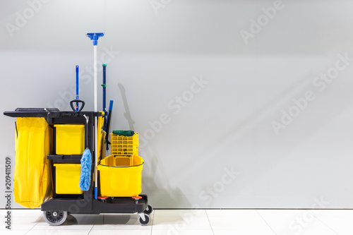 Mop bucket and set of cleaning equipment and sign of men toilet on the wall in the airport photo