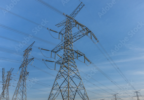 Electric poles and power lines in a  North American suburban area on a blue sky background 