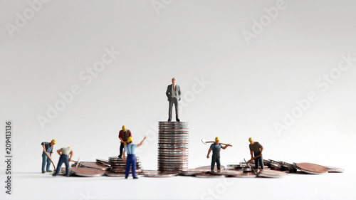 The concept of differences between social income and labor. Pile of coins and miniature people.  photo