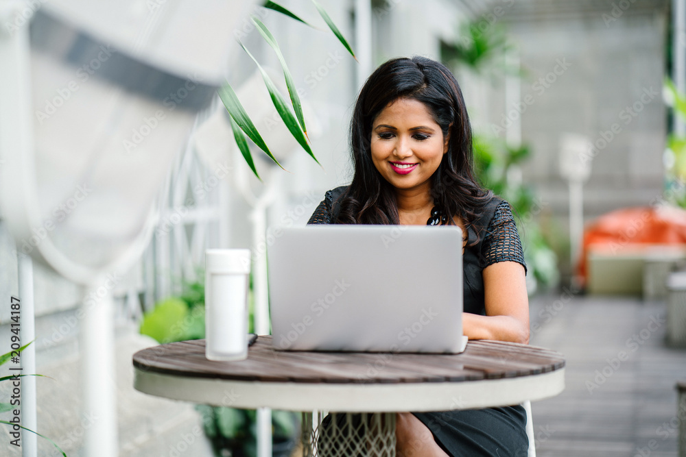 Φωτογραφία A confident and successful Indian woman (professional or business woman) is sitting and working on her laptop in the day