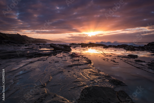 Sunrise reflecting in a pool of water at an Australian beach alongside the iconic Great Ocean Road