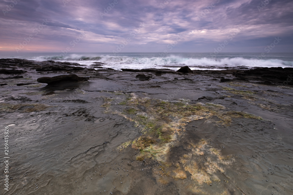 Coastline rock shelf alongside the iconic Great Ocean Road in Australia at sunrise