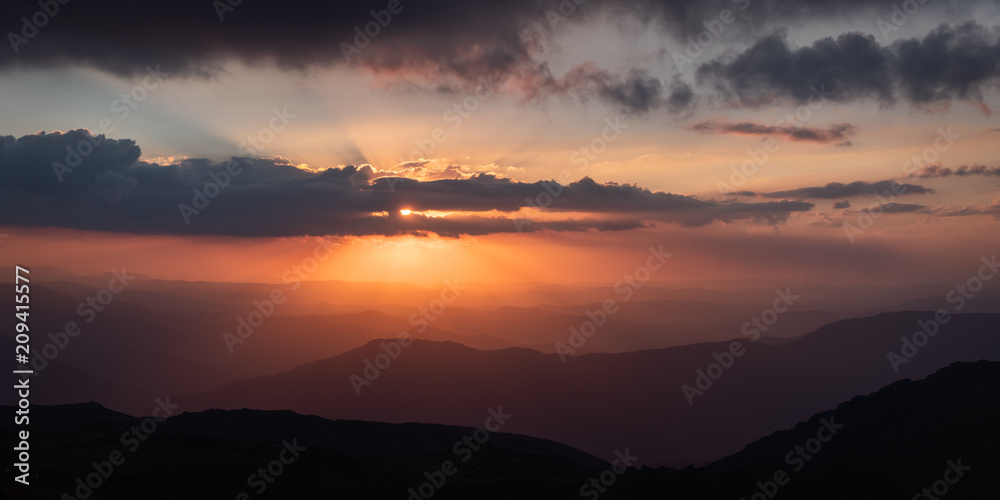 Sunset as viewed from Australia's highest mountain peak, Mt Kosciuszko. The Victorian high country can be seen in the distance.
