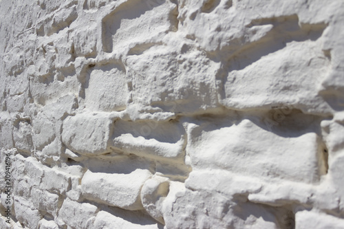 Close-up of a painted white brick wall outside.