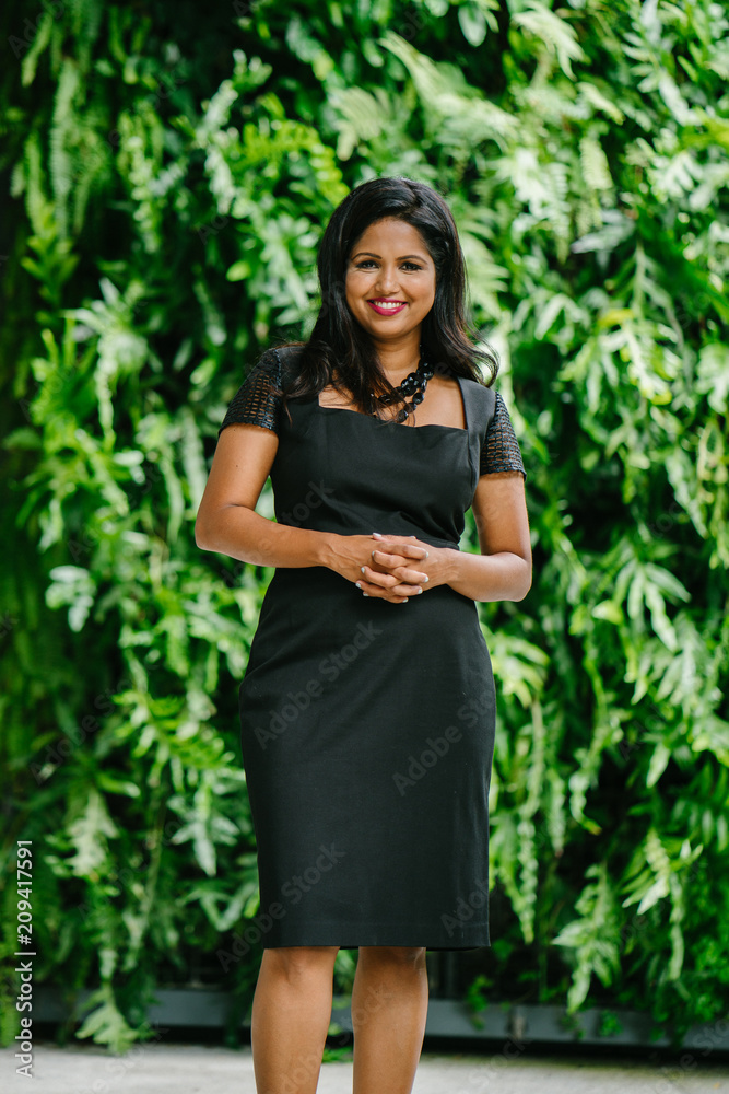 A successful leader smiling and posing in front of the camera. She is wearing a beautiful black dress and is confidently striking a pose with charm. A successful leader smiling and posing in front of the camera. She is wearing a beautiful black dress and is confidently striking a pose with charm.