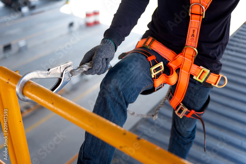 Construction worker use safety harness and safety line working on a new construction site project. photo