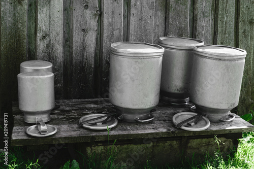 Few Drying Washed Metal Milk Canisters, Churns in the Countryside photo