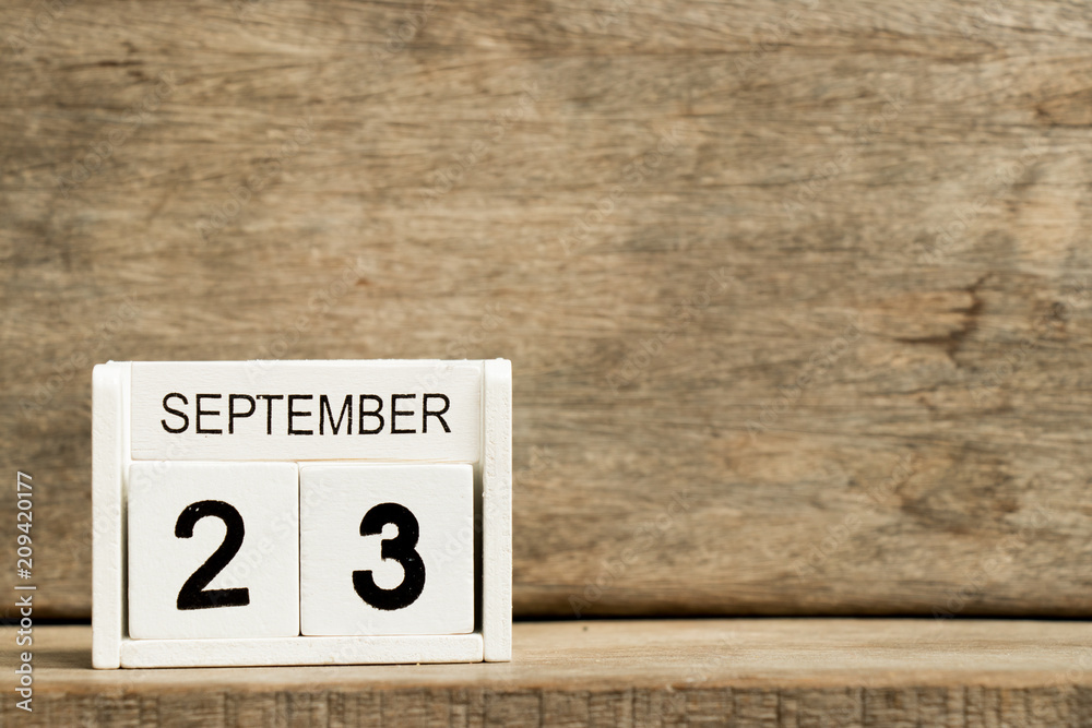 White block calendar present date 23 and month September on wood background White block calendar present date 23 and month September on wood background