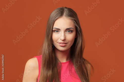 Portrait of a beautiful young woman on a brown background