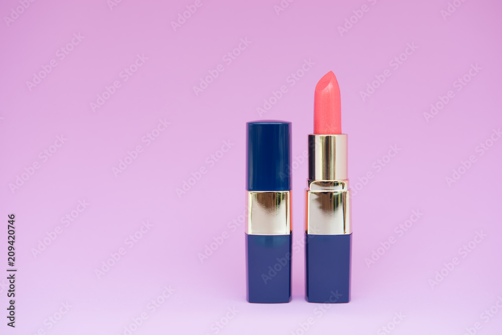 Minimal creative concept of female cosmetic for orange and close lipstick on the colorful background with copy space