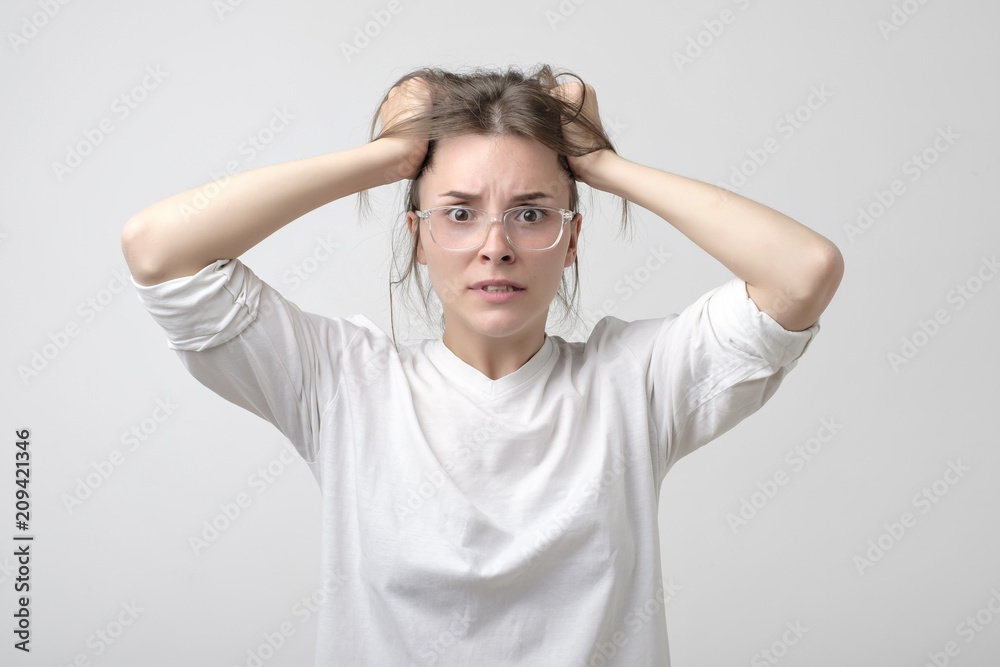 Cauasian woman in panic in studio. halding her head. She is holding her head with hands. Cauasian woman in panic in studio. halding her head. She is holding her head with hands.