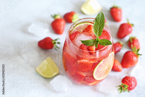 Strawberry infused water, coctail, lemonade or tea. Summer iced cold drink with strawberry, lemon and mint. Selective focus