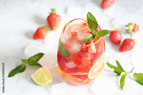 Strawberry infused water, coctail, lemonade or tea. Summer iced cold drink with strawberry, lemon and mint. Selective focus