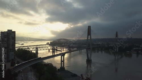 Aerial view of Fraser River and Bridges during a vibrant sunrise. Taken in New Westminster, Greater Vancouver, British Columbia, Canada. photo