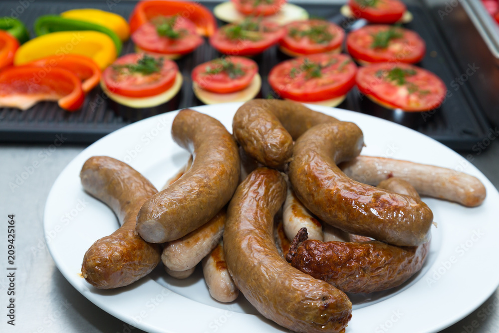 Sausages for frying in metal dishes on a professional restaurant kitchen. Selective focus. Shallow depth of field Sausages for frying in metal dishes on a professional restaurant kitchen. Selective focus. Shallow depth of field