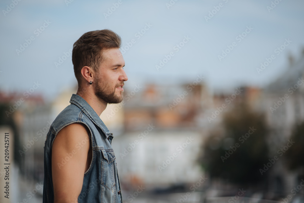 Stylish man in trendy sportive clothing performing street dance. Cool and handsome. Urban beard Handsome man keeping arms crossed and looking away while standing in front of the textured wall outdoors Stylish man in trendy sportive clothing performing street dance. Cool and handsome. Urban beard Handsome man keeping arms crossed and looking away while standing in front of the textured wall outdoors