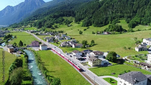 Red train of Bernina in Poschiavo city. Swiss Alps.