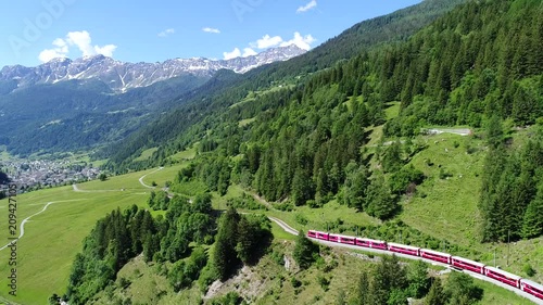 Bernina Express, red train in a forest. Val Poschiavo. Aerial view with drone