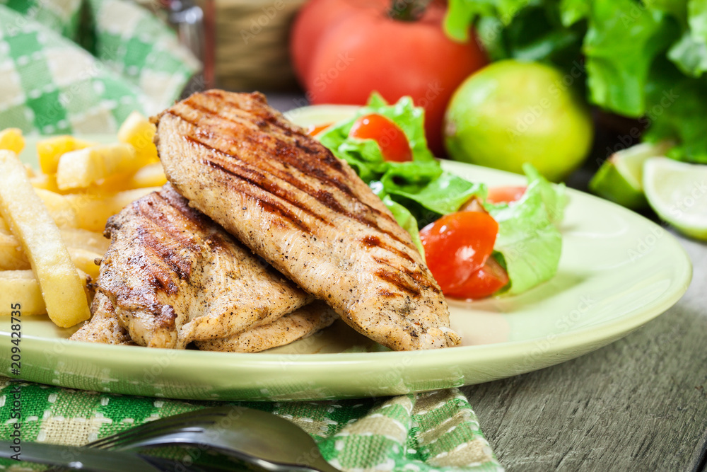 Grilled chicken breasts served with fries Grilled chicken breasts served with fries