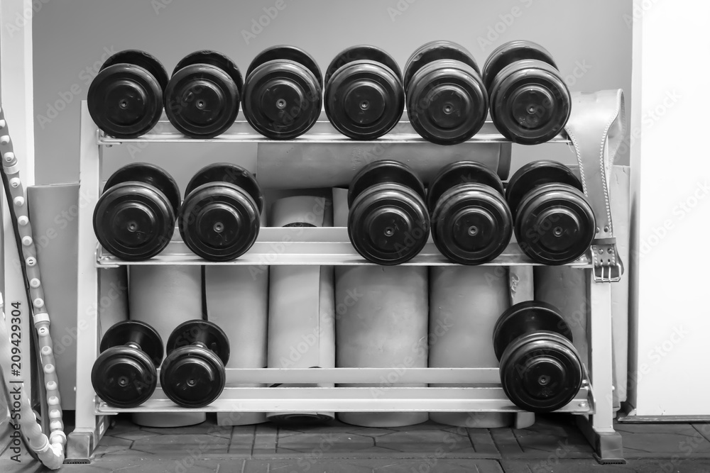 Black dumbbell set. Close up many metal dumbbells on rack ,Weight Training Equipment concept. Black dumbbell set. Close up many metal dumbbells on rack ,Weight Training Equipment concept.