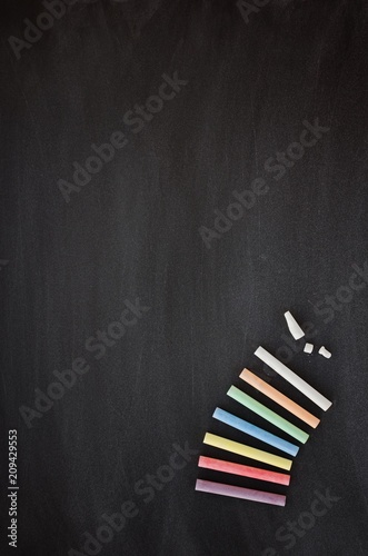 Multicolored chalk on black blackboard