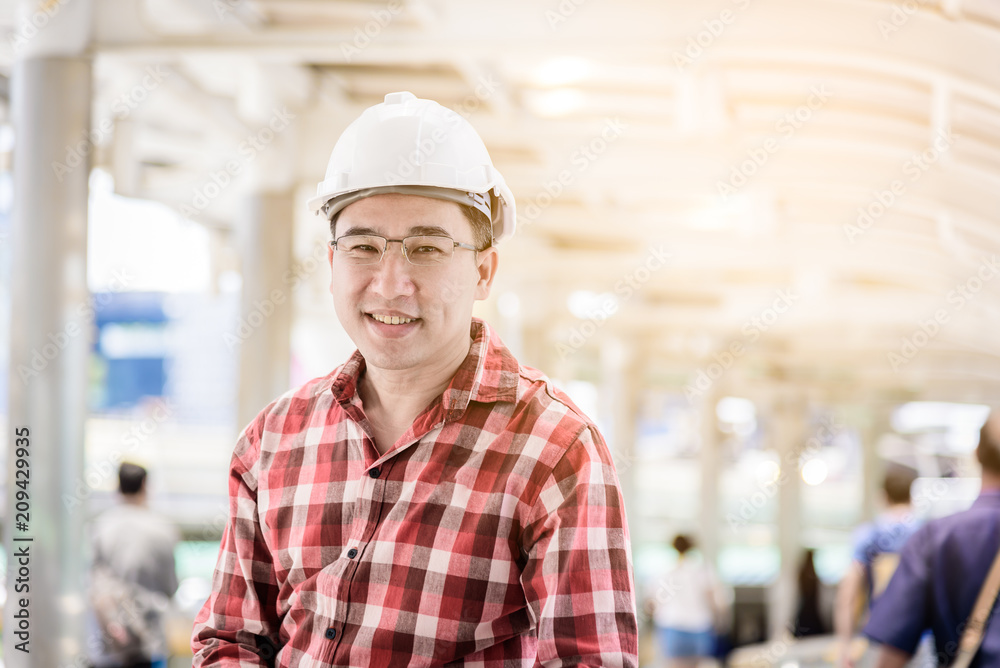 Asian business and engineer man with red scott shirt has planning and working for design buiding and city.