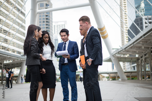 Group of business people standing in the city and discussing ideas for business future. multi culture of business people, African, Caucasian and Asian.