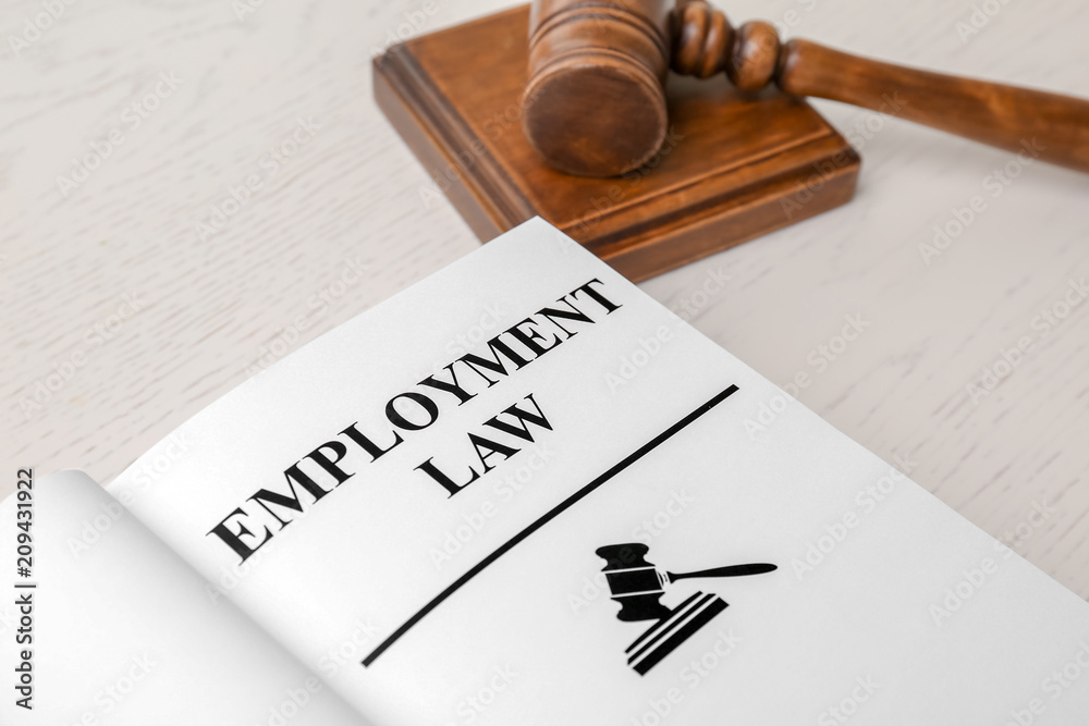 Open book with words EMPLOYMENT LAW and gavel on table, closeup Open book with words EMPLOYMENT LAW and gavel on table, closeup
