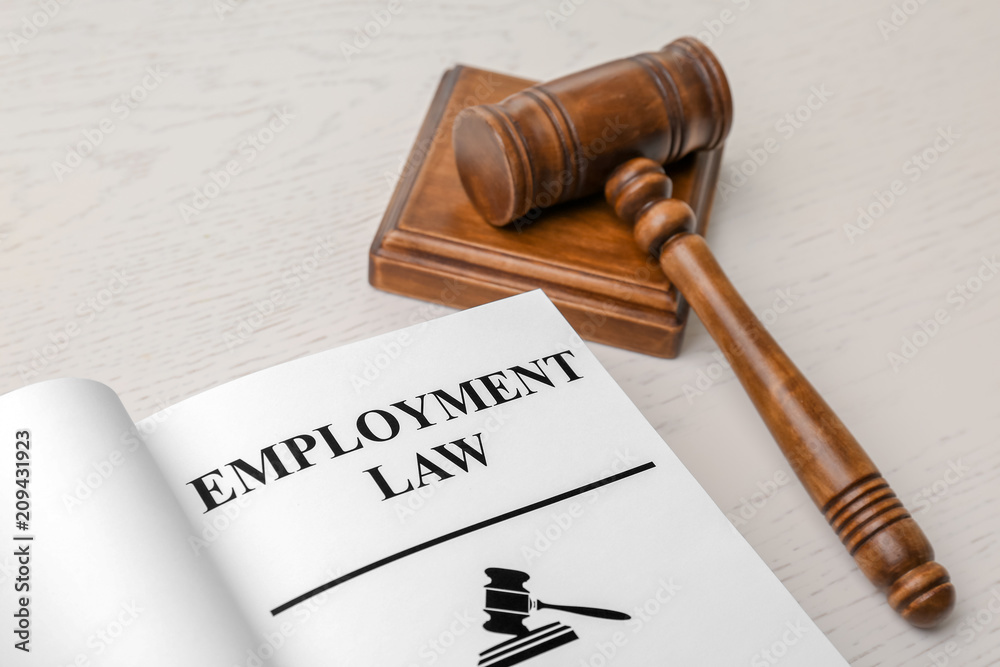 Open book with words EMPLOYMENT LAW and gavel on table, closeup Open book with words EMPLOYMENT LAW and gavel on table, closeup