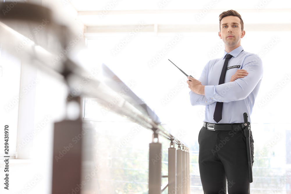 Fototapeta premium Male security guard with portable radio transmitter indoors
