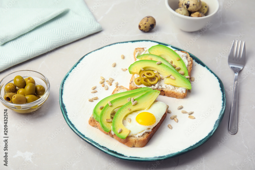 Crisp toasts with avocado and quail egg on plate