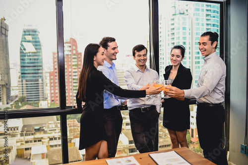 business man are business woman drinking champagne talking and smiling while celebrating in office, successful business concept.
