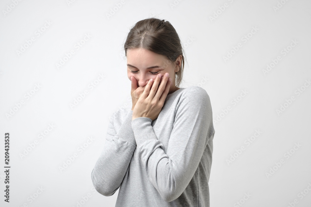 Pretty girl in simple pulover is shy to hear a compliment. She is hiding her face. Pretty girl in simple pulover is shy to hear a compliment. She is hiding her face.