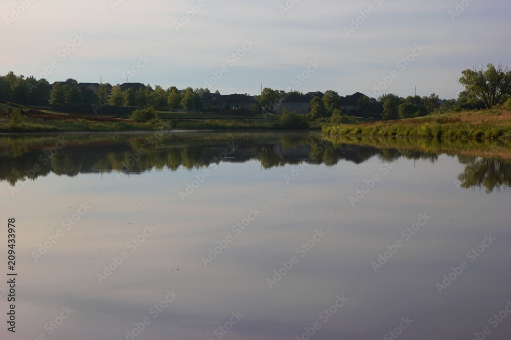 Small Lake reflection with grass shore area