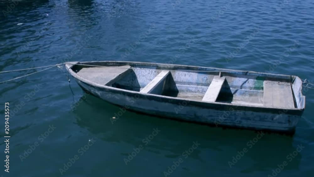 Empty boat floating on the blue sea during a sunny day. Empty boat floating on the blue sea during a sunny day.