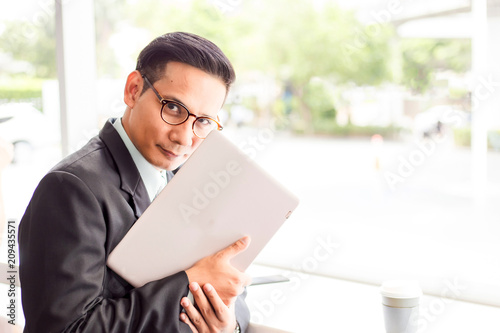 Asia business man working with laptop while sitting coffee shop .Concept of young business people