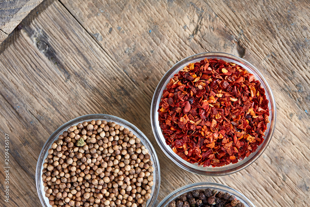 Glass bowls with various spicies on wooden barrel, top view, close-up, selective focus. Glass bowls with various spicies on wooden barrel, top view, close-up, selective focus.