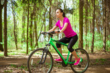 Happy Young Beautiful Woman Riding Sport Mountaine Bicycle in Forest outside. Healthy Lifestyle. Sport and Strong
