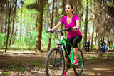 Happy Young Beautiful Woman Riding Sport Mountaine Bicycle in Forest outside. Healthy Lifestyle. Sport and Strong
