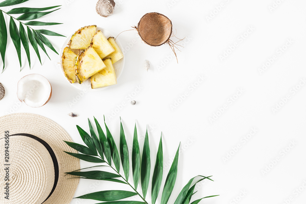 Summer composition. Tropical palm leaves, hat, pineapple, coconut on white background. Summer concept. Flat lay, top view, copy space Summer composition. Tropical palm leaves, hat, pineapple, coconut on white background. Summer concept. Flat lay, top view, copy space