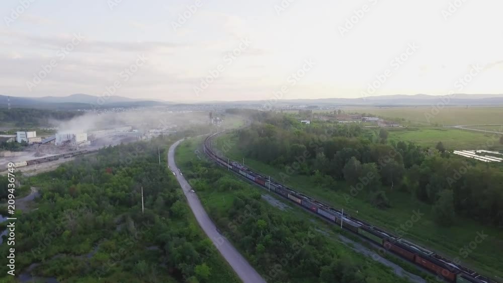 Freight train carries with coal an electric locomotive by two-sided railway in the Ural Mountains - Aerial Photography, top view Freight train carries with coal an electric locomotive by two-sided railway in the Ural Mountains - Aerial Photography, top view