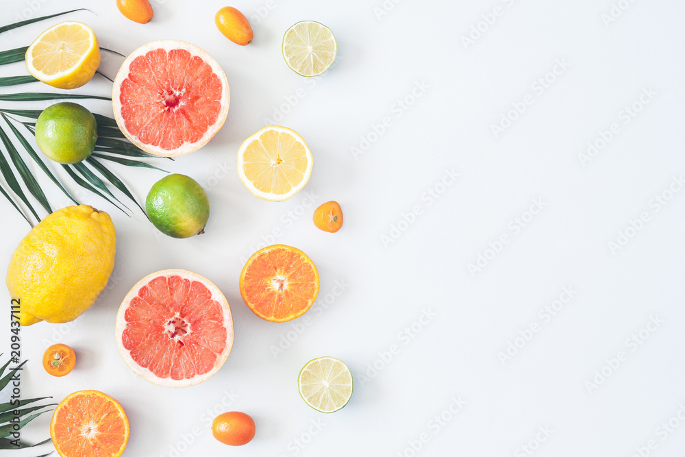 Fruit background. Colorful fresh fruits and tropical palm leaves on pastel blue background. Summer concept. Flat lay, top view, copy space Fruit background. Colorful fresh fruits and tropical palm leaves on pastel blue background. Summer concept. Flat lay, top view, copy space
