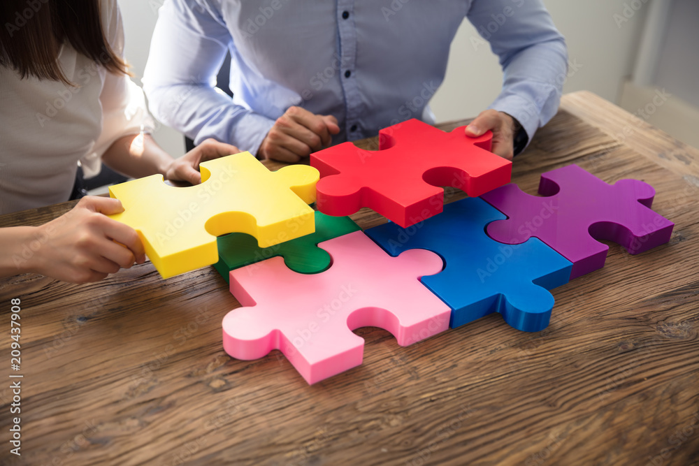 Two Businesspeople Solving Jigsaw Puzzle Two Businesspeople Solving Jigsaw Puzzle