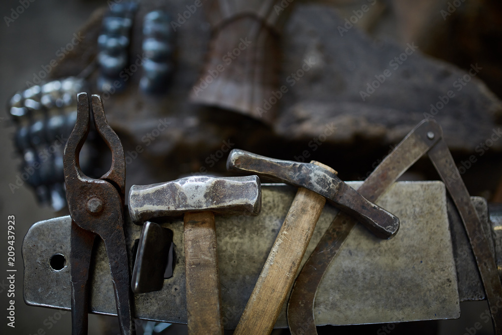Working metal tools in blacksmith's workshop, close-up, selective focus, nobody Working metal tools in blacksmith's workshop, close-up, selective focus, nobody
