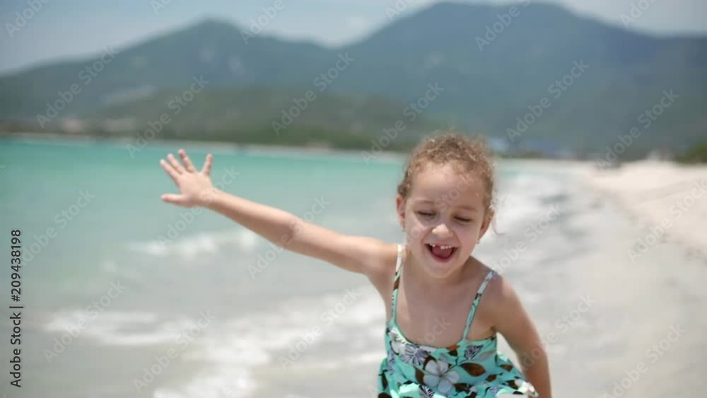 Adorable little girl runs down the beach toward her mother for a big hug and kiss. Close up shot. Stock footage Adorable little girl runs down the beach toward her mother for a big hug and kiss. Close up shot. Stock footage